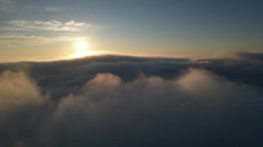 Gün batımında bulutların üzerinde uçarken