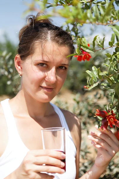 Adult woman drinking pomegranate juice — Stock Photo, Image