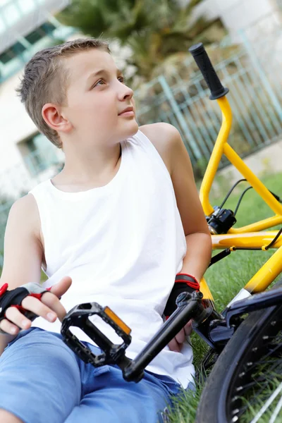 Een jongen en een fiets buiten — Stockfoto