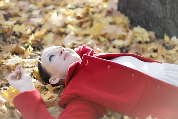Jolie fille couchée dans les feuilles d'automne — Photo
