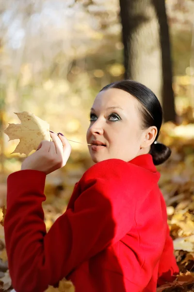 Jolie fille se détendre dans les feuilles d'automne — Photo