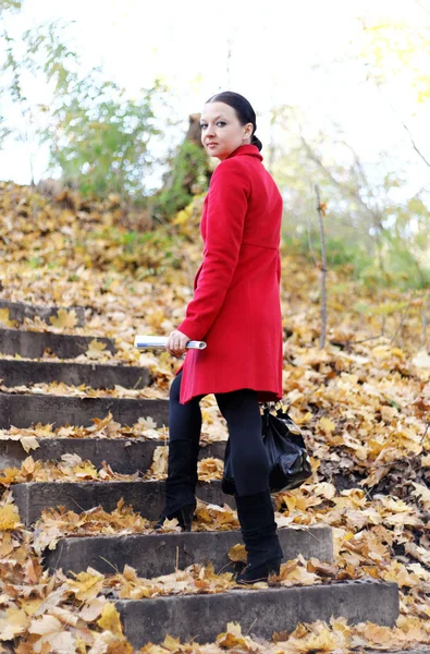 빨간 외 투에 있는 여자는 사다리가을 — 스톡 사진