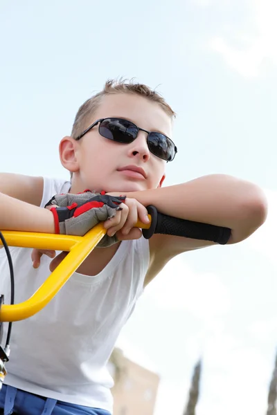 Jongen met een bril op een fiets — Stockfoto