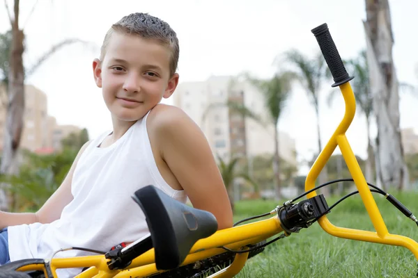 Menino com uma bicicleta sentada — Fotografia de Stock