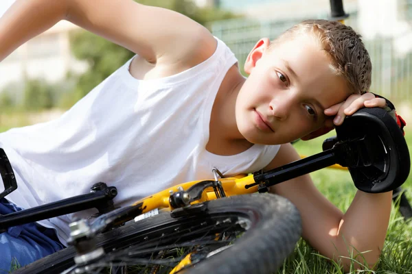 Boy rests with the bike Stock Photo