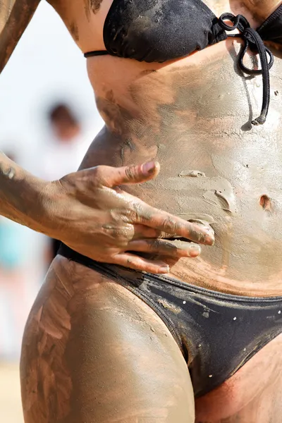 Meisje in bikini in de modder — Stockfoto