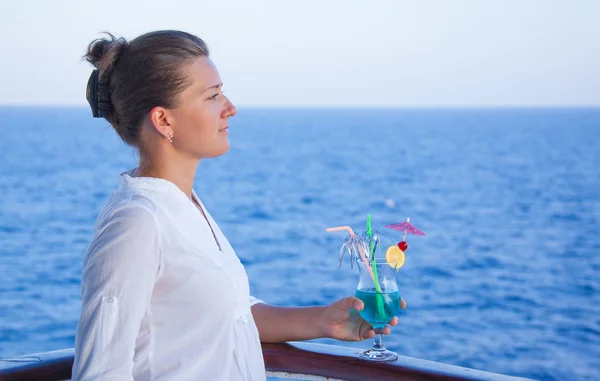 Jolie fille boire une boisson froide, admirant la vue sur la mer — Photo
