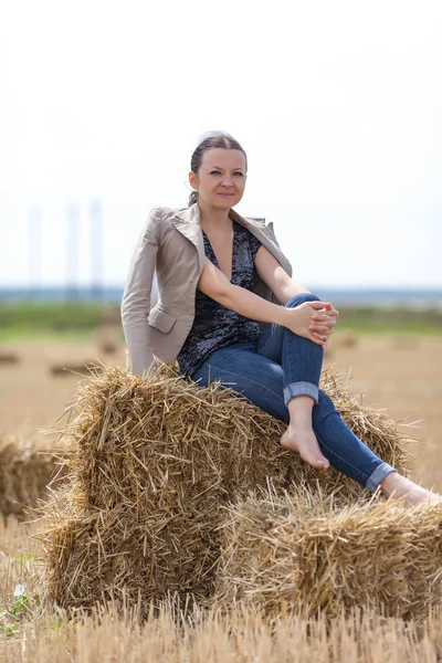 Flicka sitter på en bunt — Stockfoto