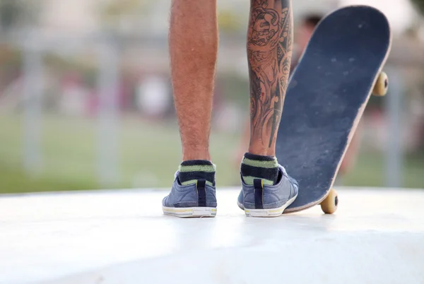 Tätowiertes Bein mit Skateboard — Stockfoto