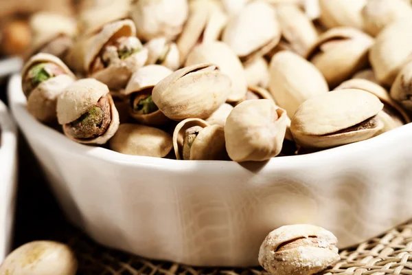 Pimpernoten (pistaches) in een kom achtergrond — Stockfoto