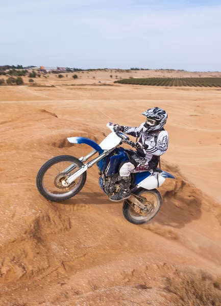 Racer på en motorcykel upp för backen — Stockfoto