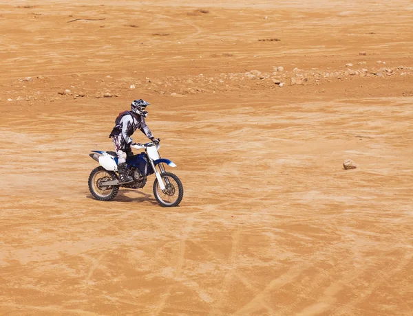 Racer on a motorcycle ride through the desert — Stock Photo, Image