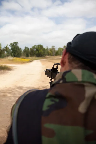 Homem armado com uma arma está segurando a arma — Fotografia de Stock