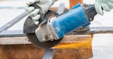 Metali yakın plan kesen dairesel bir testereyle çalışıyor.