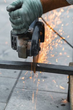 Metali yakın plan kesen dairesel bir testereyle çalışıyor.