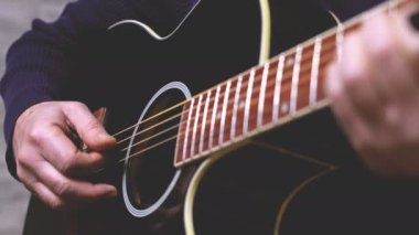 man playing guitar, hands on strings close-up