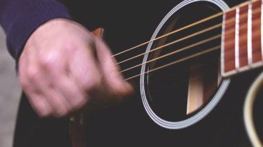 man playing guitar, hands on strings close-up