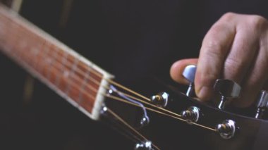 tuning guitar strings, hands close up