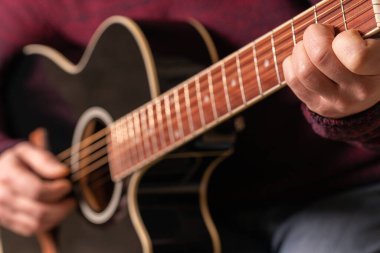 man playing guitar, hands on strings close-up