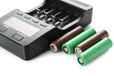 Beyaz izole arkaplanda pilleri olan şarj cihazı 