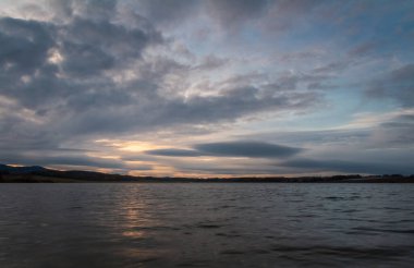 İnanılmaz dramatik günbatımı gökyüzü kümülüs bulutu ile Dehtar göletinde. Çek manzarası