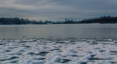 Göl kıyısında kar bulutlu gökyüzünde. Çek kış manzarası