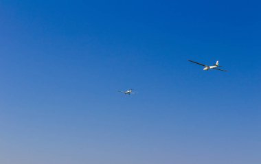 Ultra ışık, cessna uçağı mavi gökyüzünde uzun bir iple planörle sürükleniyor. Spor, havacılık arka planı