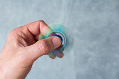 Mermer arka planda dönen metalik döner el ele tutuşan bir adam. Stres önleyici oyuncak