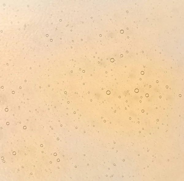 Shampoo honey bubble texture background. Ochre clean soap, cosmetics backdrop
