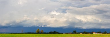 Panoramik manzara küçük bir çeçen köyü, yol ve ağaçlar süperhücre fırtınası altında gökyüzü. Dramatik manzara