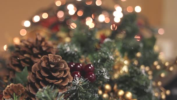 マツ円錐形、ベリー類、きらめく照明背景のボケ味とクリスマスの花輪の装飾 — ストック動画