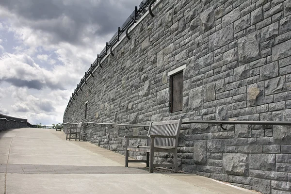 Bänke entlang der Steinmauer öffentlicher Parks — Stockfoto