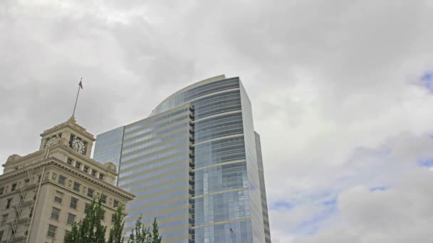 Snel bewegende witte wolken over een historische mijlpaal en een modern gebouw in portland oregon op een winderige dag time-lapse 1080p — Stockvideo