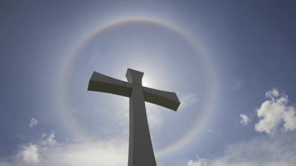 Cruz de crucifijo con Halo Sun Flare Timelapse con nubes blancas en movimiento contra Blue Sky 1080p — Vídeo de stock