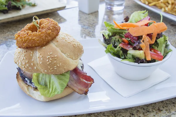 Hamburger z pierścieniem cebuli i sałatka kolorowy — Zdjęcie stockowe