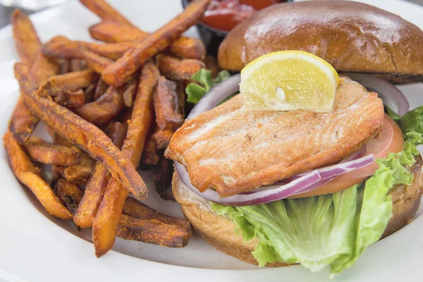 Zalm sandwich met zoete aardappel frietjes close-up — Stockfoto