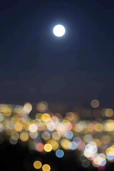 Lever de pleine lune sur les lumières floues de la ville — Photo