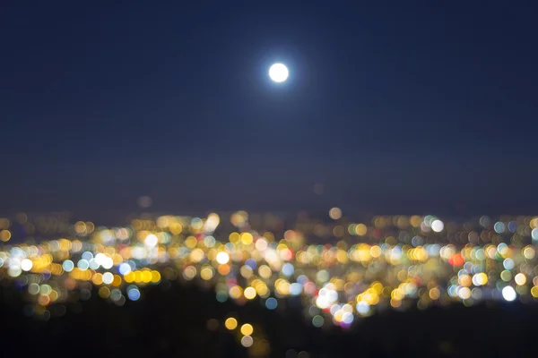 Vollmondaufgang über verschwommener Stadtlichtlandschaft — Stockfoto