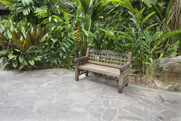 Panca in legno nel giardino tropicale — Foto Stock