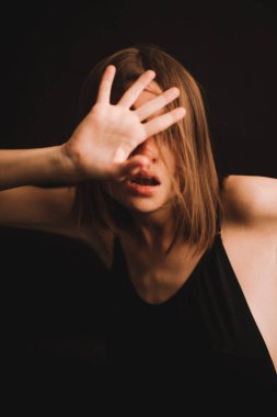 Stüdyodaki bir kızın duygusal portresi, kamerada zor duygular ifade eden bir kadın, yakın planda bir kadının ruh hali. Portredeki yumuşak odak bulanık ve bulanık arkaplan