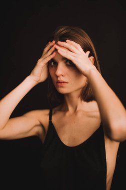 Stüdyodaki bir kızın duygusal portresi, kamerada zor duygular ifade eden bir kadın, yakın planda bir kadının ruh hali. Portredeki yumuşak odak bulanık ve bulanık arkaplan