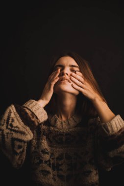 Stüdyodaki bir kızın duygusal portresi, kamerada zor duygular ifade eden bir kadın, yakın planda bir kadının ruh hali. Portredeki yumuşak odak bulanık ve bulanık arkaplan