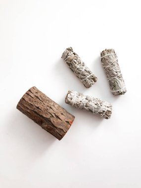 Yakından bir demet kuru beyaz adaçayı. Arındırma, meditasyon ve iyileştirme için ürün. Tesisleri dezenfekte etmek için tütsü. Beyaz arka planda beyaz adaçayı dalları. Yukarıdan görüntüle.