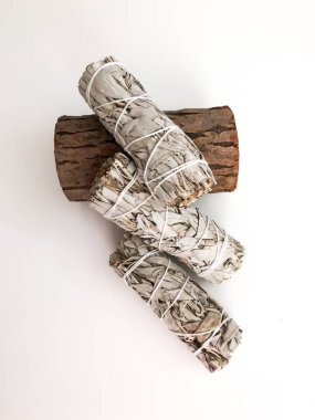 Yakından bir demet kuru beyaz adaçayı. Arındırma, meditasyon ve iyileştirme için ürün. Tesisleri dezenfekte etmek için tütsü. Beyaz arka planda beyaz adaçayı dalları. Yukarıdan görüntüle.