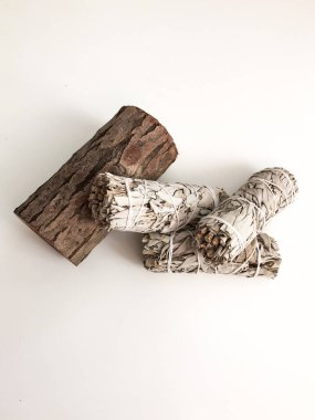 Yakından bir demet kuru beyaz adaçayı. Arındırma, meditasyon ve iyileştirme için ürün. Tesisleri dezenfekte etmek için tütsü. Beyaz arka planda beyaz adaçayı dalları. Yukarıdan görüntüle.