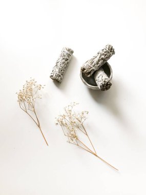 Beyaz bir arka planda beyaz Kaliforniya adaçayı sürüsü, minimalizm ve yazı için bir yer. Kutsal tütsü, aromaterapi ve meditasyon.