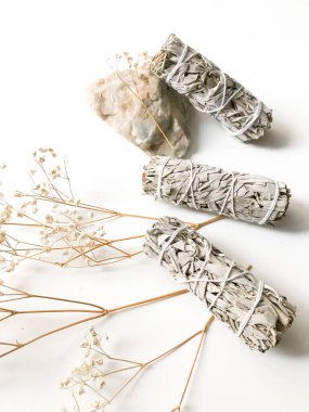 Beyaz bir arka planda beyaz Kaliforniya adaçayı sürüsü, minimalizm ve yazı için bir yer. Kutsal tütsü, aromaterapi ve meditasyon.