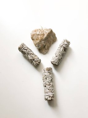 Beyaz bir arka planda beyaz Kaliforniya adaçayı sürüsü, minimalizm ve yazı için bir yer. Kutsal tütsü, aromaterapi ve meditasyon.
