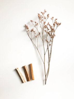 Ahşap palo santo sopalarının, aromaterapinin ve beyaz arka plandaki aromaların büyüsünün çok güzel bir arka planı var. Işık görüntüsü bulanıklaşması, odak eksikliği, yumuşak doku kombinasyonları.