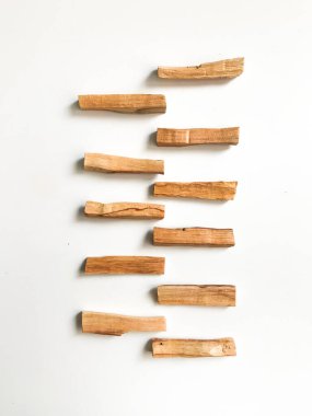 Ahşap palo santo sopalarının, aromaterapinin ve beyaz arka plandaki aromaların büyüsünün çok güzel bir arka planı var. Işık görüntüsü bulanıklaşması, odak eksikliği, yumuşak doku kombinasyonları.